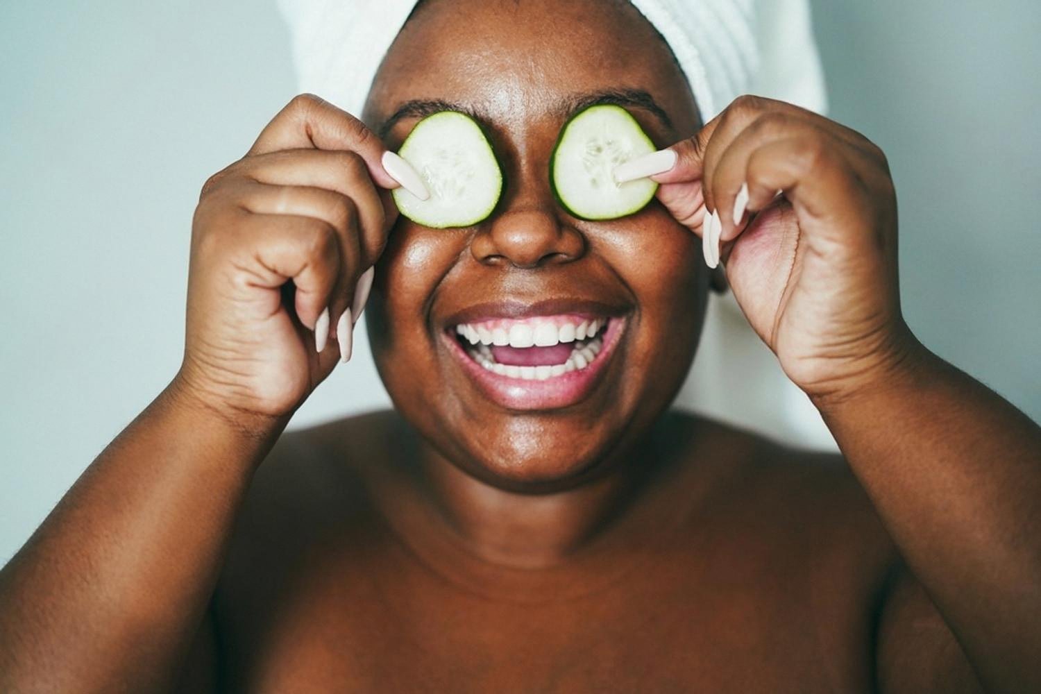 Woman relaxing with cucumber slices during a hydrating home skincare routine after sun exposure