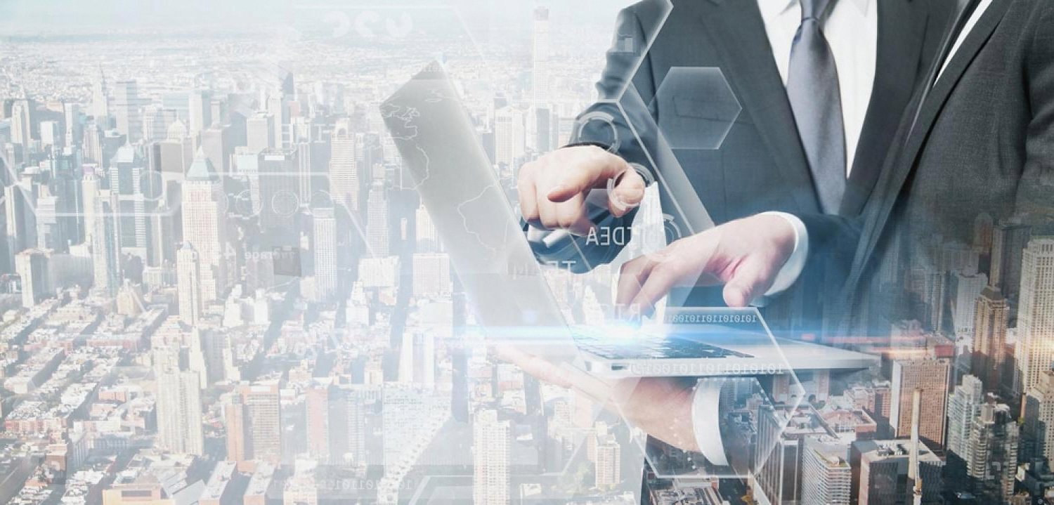Executive working on a laptop over a city skyline symbolising UBO compliance for UAE businesses